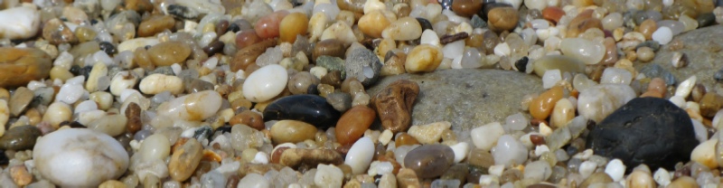bunter Kies, runde Steine in verschiedenen Farben und Grössen am Strand, glänzen vom gerade überspülten Wasser - Andreas Bertram-Weiss, Supervisor ǀ Mehr-Blick-Supervision - Gruppensupervision