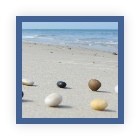 Steine im Kreis am Strand - im Hintergrund das Meer - Gruppensupervision